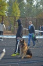 Adolescent wearing a baseball cap and hoodie with his pet stands in front of the barrier tape. Owner with a German Shepherd dog