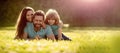 Family day. Banner of Happy family Lying on grass. Young mother and father with child son in the park resting together Royalty Free Stock Photo