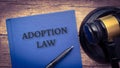 Adoption law book and gavel on wooden table. Royalty Free Stock Photo