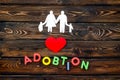 Adoption word and family figure for adopt child concept on wooden background top view