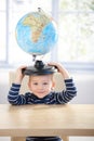 Adorable 3 year old having fun with globe smiling