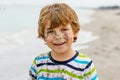 Adorable active little kid boy having fun on beach of North Sea in Germany. Happy cute child relaxing, playing and