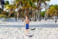 Adorable active little kid boy having fun on Miami beach, Key Biscayne. Happy cute child feeding seagull birds on sunny