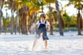 Adorable active little kid boy having fun on Miami beach, Key Biscayne. Happy cute child relaxing, playing with sand and