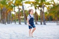 Adorable active little kid boy having fun on tropical beach of island. Happy cute child relaxing, playing, enjoying Royalty Free Stock Photo