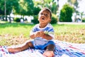 Adorable african american chubby toddler sitting on the grass at the park