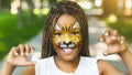 Adorable african-american girl with creative face painting roaring Royalty Free Stock Photo