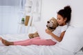 adorable african american kid reading book and hugging teddy bear Royalty Free Stock Photo