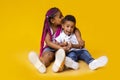 Adorable african american siblings sitting on floor and cuddling