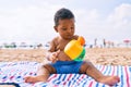 Adorable african american toddler playing with toys sitting on the sand at the beach Royalty Free Stock Photo