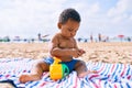 Adorable african american toddler playing with toys sitting on the sand at the beach Royalty Free Stock Photo