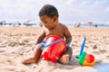 Adorable african american toddler playing with toys sitting on the sand at the beach Royalty Free Stock Photo