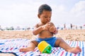 Adorable african american toddler playing with toys sitting on the sand at the beach Royalty Free Stock Photo