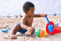 Adorable african american toddler playing with toys sitting on the sand at the beach Royalty Free Stock Photo