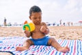 Adorable african american toddler playing with toys sitting on the sand at the beach Royalty Free Stock Photo