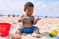 Adorable african american toddler playing with toys sitting on the sand at the beach Royalty Free Stock Photo