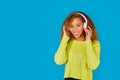 Adorable african american woman with pink headphones listening to music, blue background Royalty Free Stock Photo