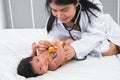 Adorable African and Asian newborn baby one month old girl check up examines by pediatrician. Doctor woman using stethoscope Royalty Free Stock Photo