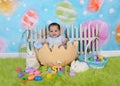 Adorable african baby sitting in giant easter egg Royalty Free Stock Photo
