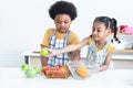 Adorable African children, brother and sister in apron preparing food meal in kitchen, have fun classify color and type of fruits