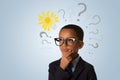Adorable african american  boy wearing glasses and thinking with many question marks and lightbulb. Concept of ideas Royalty Free Stock Photo