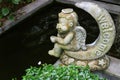Adorable angel sitting on a crescent moon welcome sculpture at the garden pond side Royalty Free Stock Photo