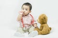 Adorable asian baby boy in pink shirt plays in doctor toy bear and red stethoscope.Health care and medical concept Royalty Free Stock Photo