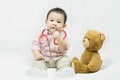 Adorable asian baby boy in pink shirt plays in doctor toy bear and red stethoscope.Health care and medical concept Royalty Free Stock Photo