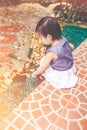 Asian child with gardening equipment. Outdoors for children. Vintage tone.