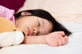 Adorable Asian child girl sleeping on the bed. In bedroom. Sleeping little cute kid with doll. Royalty Free Stock Photo