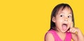 Adorable Asian child thinking and wearing pink dress isolated on a yellow background Royalty Free Stock Photo