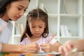 An adorable Asian elementary school girl is focusing on studying. Kids education concept Royalty Free Stock Photo