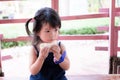 Adorable Asian girl eating bread while traveling. Cute little child is hungry. Children wear cute dark clothes. Royalty Free Stock Photo