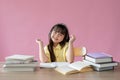 An adorable Asian girl enjoys listening to music on her headphones at her study table Royalty Free Stock Photo