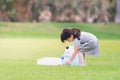 Adorable Asian girl is helping to collect plastic bottles on the lawn. Cute kid carrying garbage bags in the green lawn.