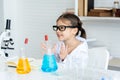 Adorable Asian girl sitting in science room learning science, doing real things, expressing joy who learned to do science Royalty Free Stock Photo