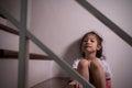 Adorable asian girl who expresses her sadness emotion on house stair alone shows concept of depression, emotional pain and Royalty Free Stock Photo