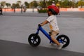 Adorable Asian kid boy Toddler age 1-year-old, Wearing a Safety Helmet and Learning to Ride a Balance Bike in the Play Space Royalty Free Stock Photo