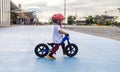 Adorable Asian kid boy Toddler age 1-year-old, Wearing a Safety Helmet and Learning to Ride a Balance Bike in the Play Space Royalty Free Stock Photo