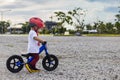 Adorable Asian kid boy Toddler age 1-year-old, Wearing a Safety Helmet and Learning to Ride a Balance Bike in the Play Space Royalty Free Stock Photo