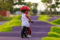 Adorable Asian kid boy Toddler age 1-year-old, Wearing a Safety Helmet and Learning to Ride a Balance Bike in the Play Space Royalty Free Stock Photo