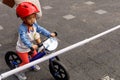 Adorable Asian kid boy Toddler age 1-year-old, Wearing a Safety Helmet and Learning to Ride a Balance Bike in the Play Space Royalty Free Stock Photo