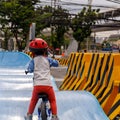 Adorable Asian kid boy Toddler age 1-year-old, Wearing a Safety Helmet and Learning to Ride a Balance Bike in the Play Space Royalty Free Stock Photo