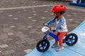 Adorable Asian kid boy Toddler age 1-year-old, Wearing a Safety Helmet and Learning to Ride a Balance Bike in the Play Space Royalty Free Stock Photo