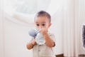 Adorable asian little baby boy drinking water from bottle at home Royalty Free Stock Photo