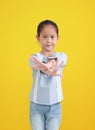 Adorable asian little kid girl reaching cross arm hands break in front of isolated over yellow background Royalty Free Stock Photo