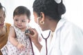 Adorable Asian newborn baby three months old girl check up examines by pediatrician. Doctor using stethoscope examining little Royalty Free Stock Photo