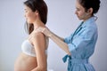 Adorable asian pregnant female getting spa massage on back, hugging tummy Royalty Free Stock Photo