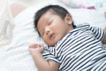 Adorable Asian sleeping, tiny infant healthy sleep with warm wool white blanket at home, baby health care concept. Royalty Free Stock Photo