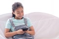 Adorable Asian smart girl in casual close her eyes by hands after playing game many hours or texting to friend on smartphone, kid